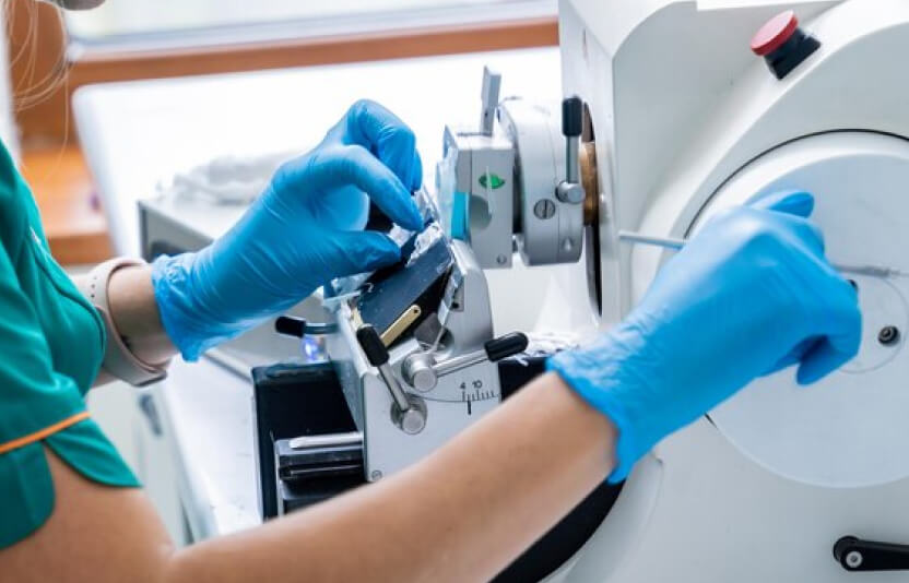 врач осматривает предметное стекло из микроскопа